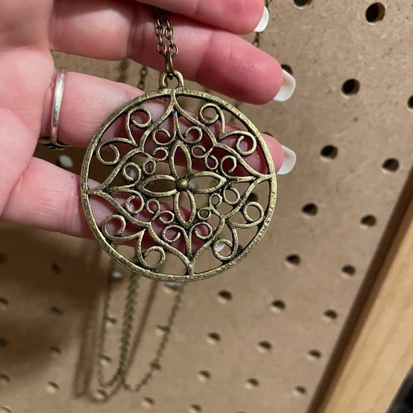 Extra long full copper chain necklace with an open work medallion.